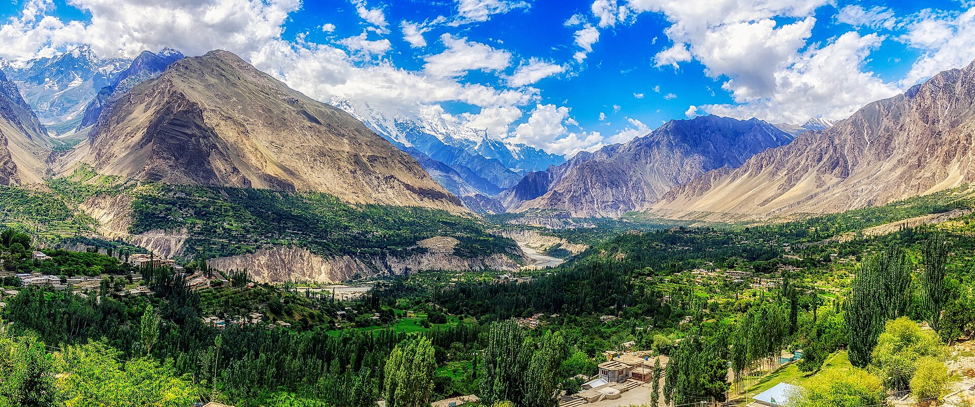 The Hunza valley from above, villages and poplars on the green valley floor below the bare ridges the marble beds run through